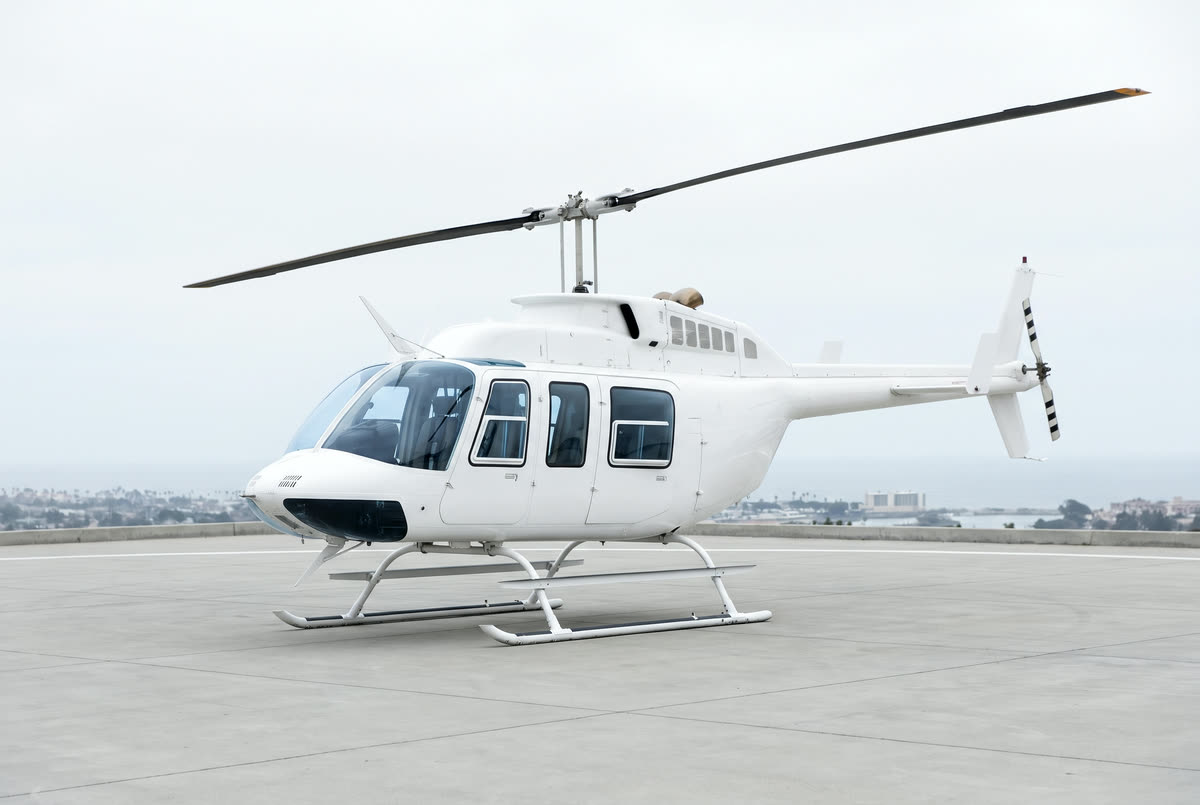 A Bell 206L3 LongRanger helicopter on a helipad, unmarked, seen from the front left