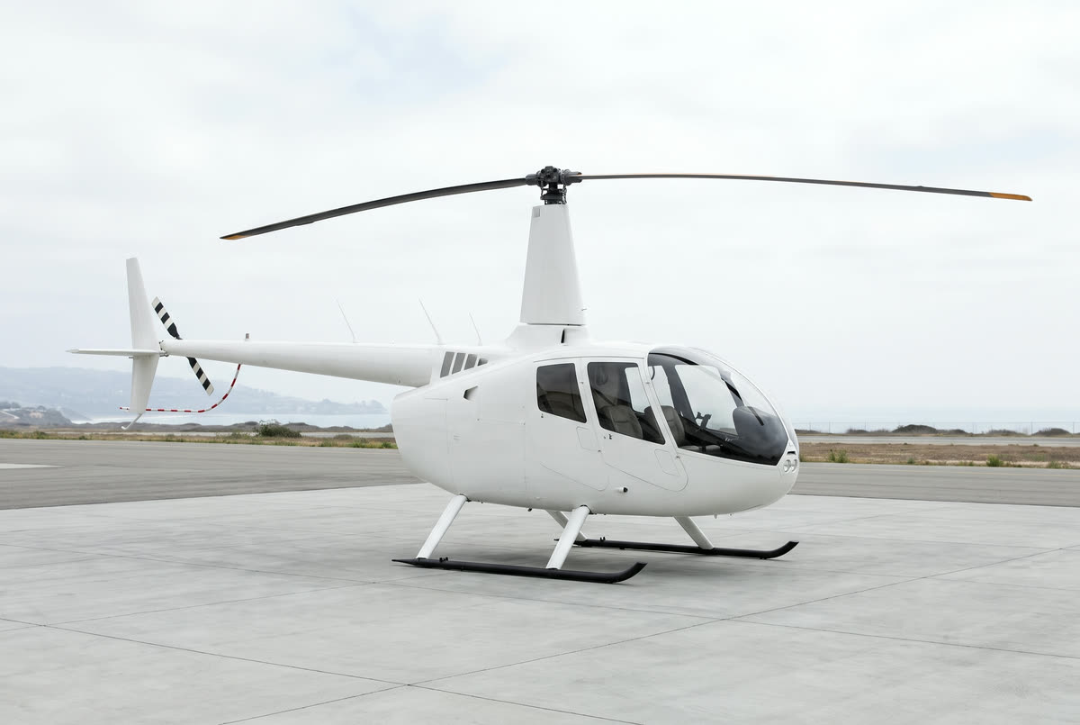A Robinson R66 helicopter on a helipad, unmarked, seen from the front left